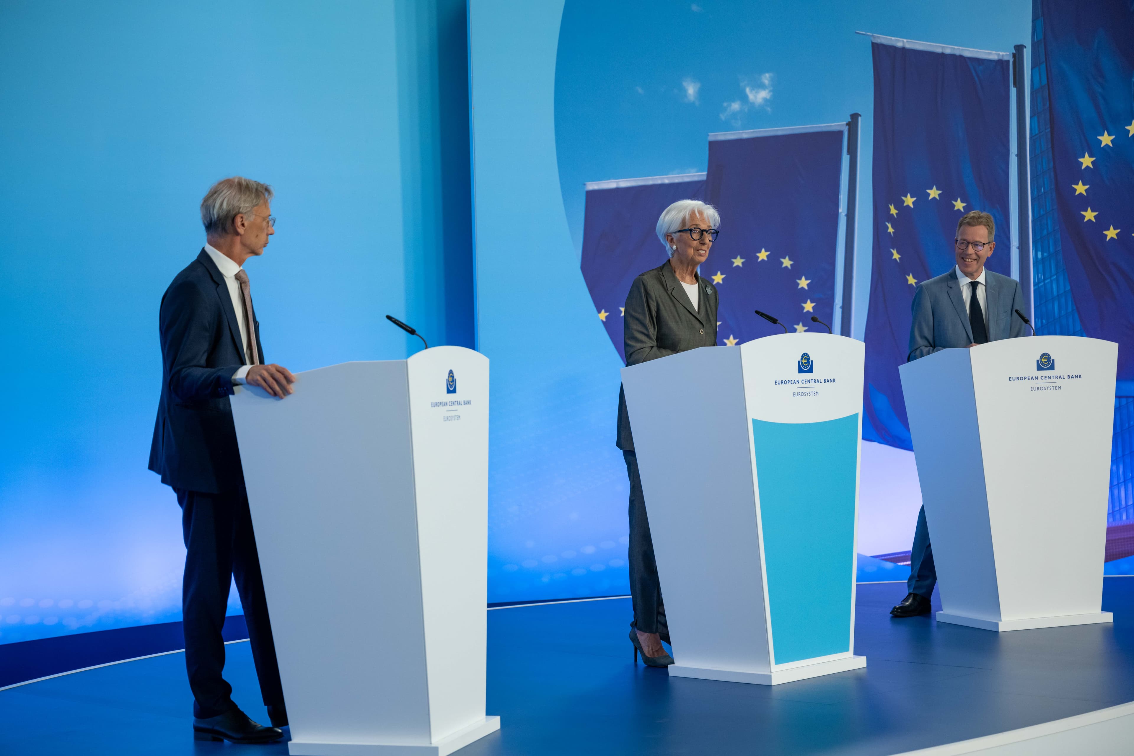 Drie vertegenwoordigers van de Europese Centrale Bank tijdens de persconferentie van 23 juli 2026