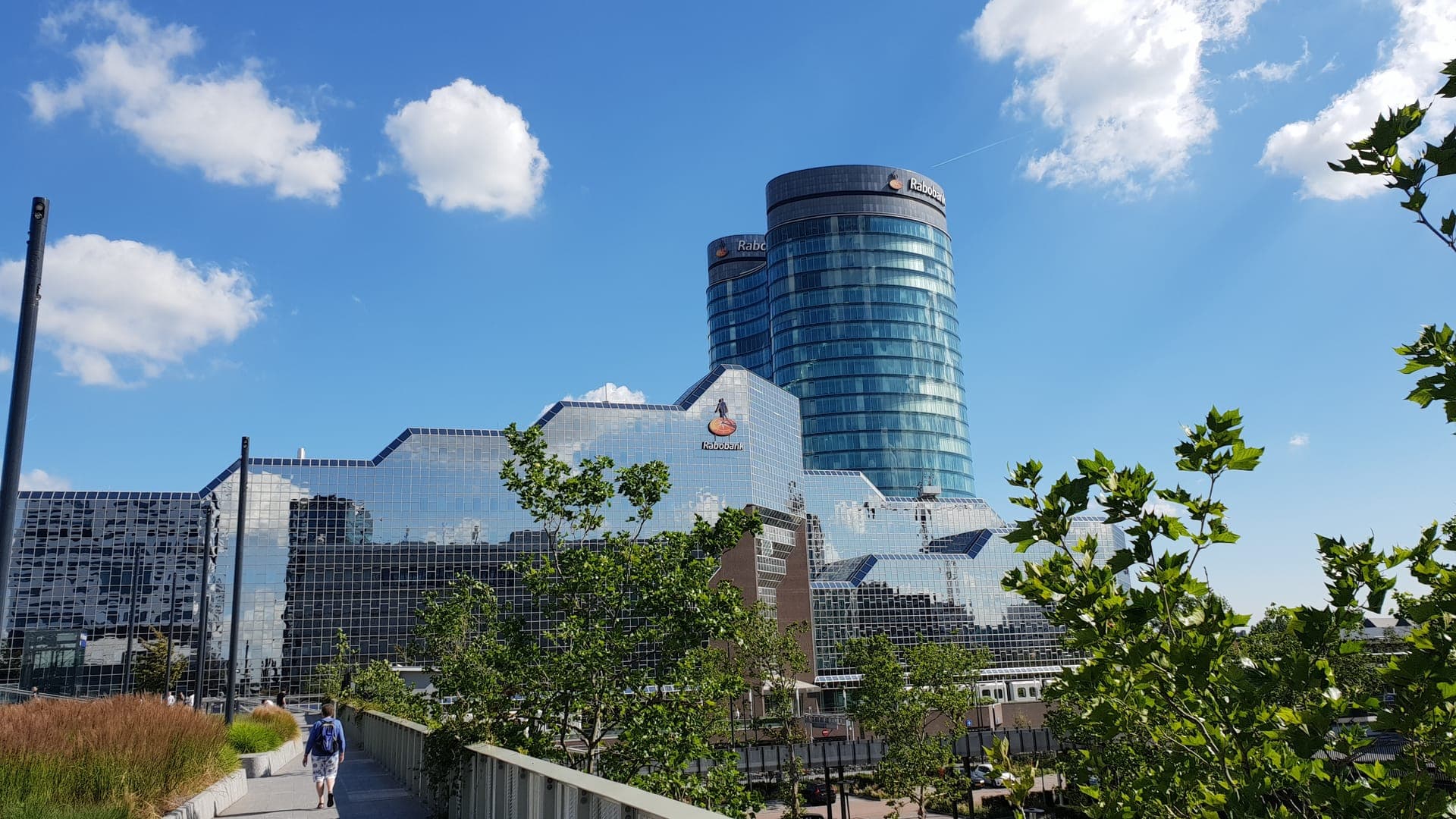 Het hoofdkantoor van Rabobank in Utrecht, met de ronde glazen torens achter een gebouw met spiegelende gevel