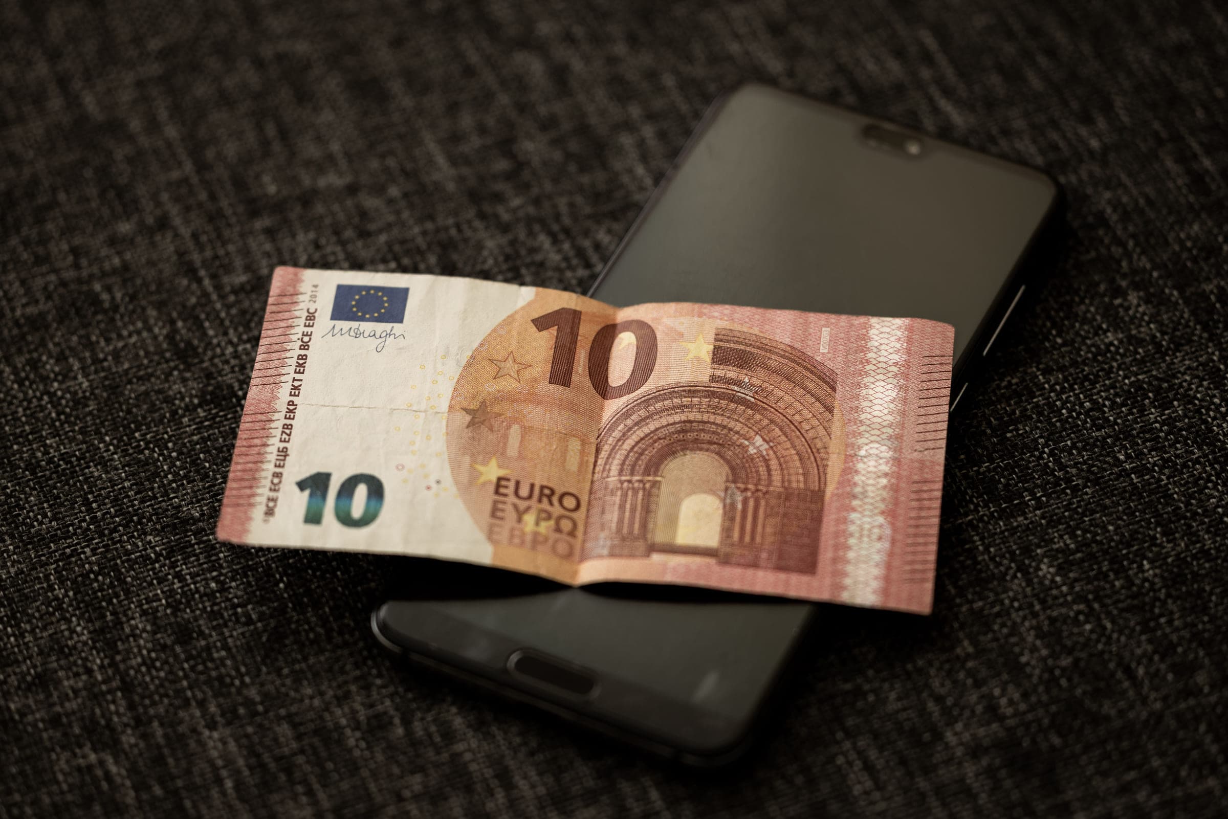 Eurobankbiljet op een smartphone als beeld voor digitaal sparen en cashbeheer