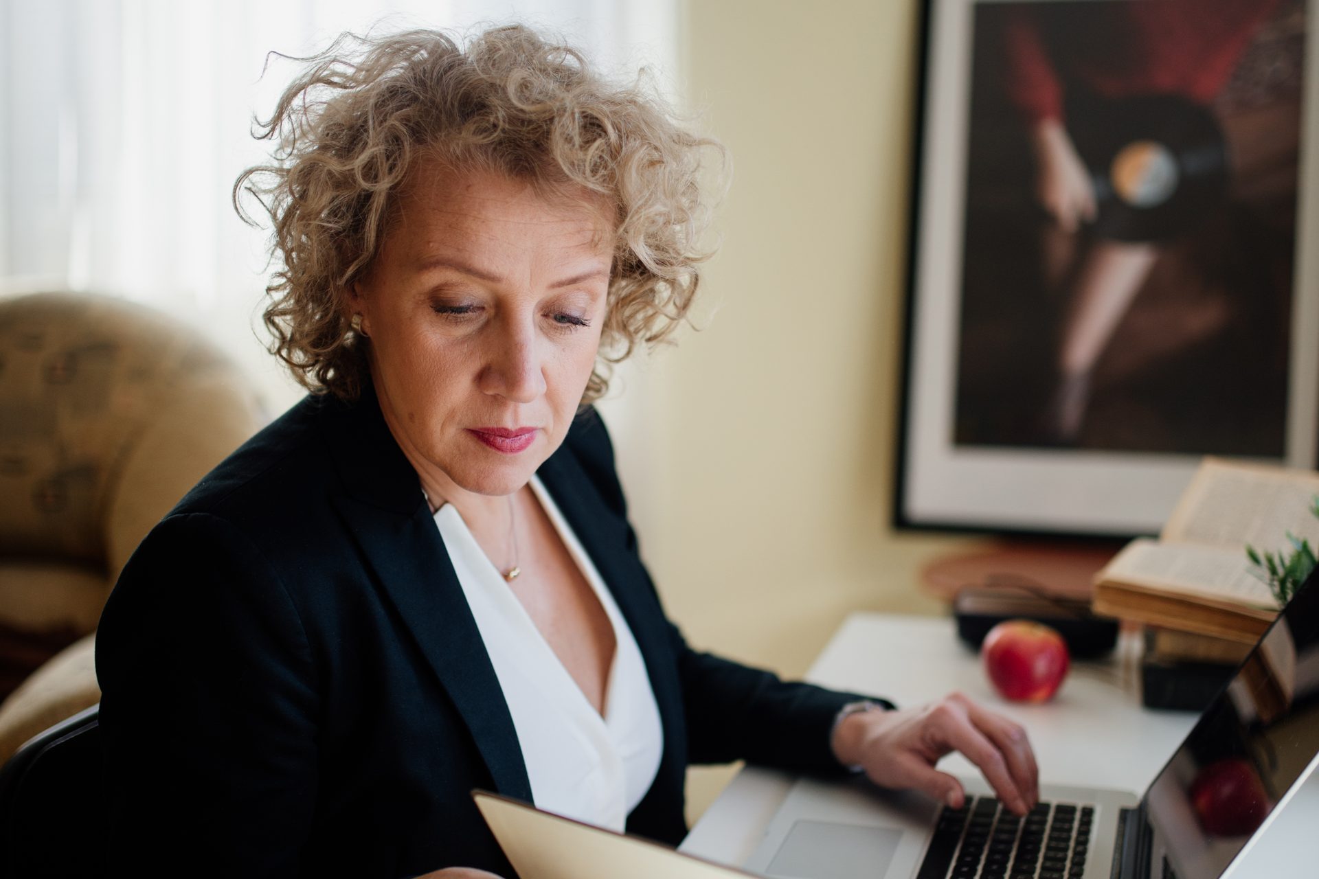 Een ondernemer aan een bureau met een laptop en een opengeslagen notitieboek